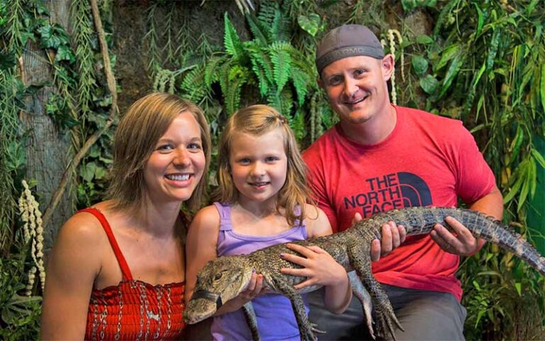 family-holding-small-alligator-at-gator-beach-destin-768x480